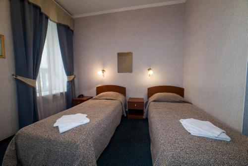 Habitación de hotel con 3 camas y toallas. en Амулет на Большом, en San Petersburgo