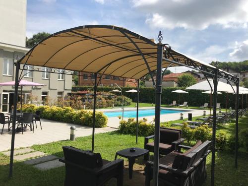 pawilon z krzesłami, stołem i basenem w obiekcie Bis Hotel Varese w mieście Varese