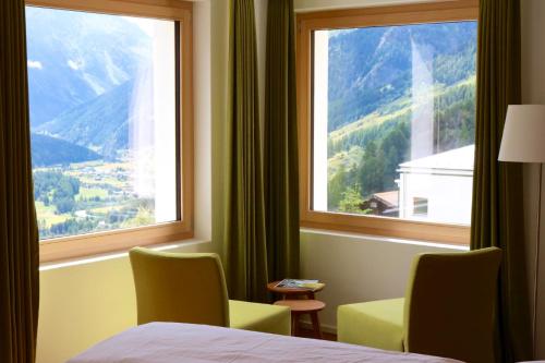 a room with a bed and two chairs and a window at Guarda Lodge in Guarda