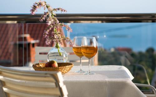 a table with two glasses of wine and a basket of fruit at Villa Sv. Vid in Sevid