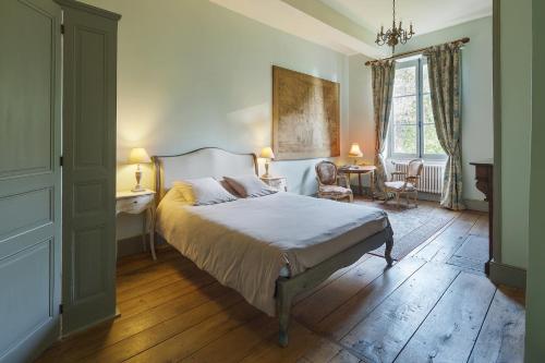 a bedroom with a bed and a table and chairs at Abbaye du Palais in Thauron