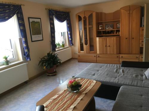 ein Wohnzimmer mit einem Sofa und einem Tisch in der Unterkunft Ferienwohnung Inge Blum in Müllenbach