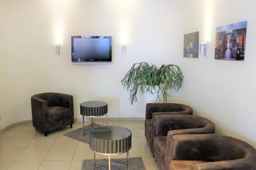 a waiting room with two couches and a flat screen tv at Novum Hotel Eleazar City Center in Hamburg