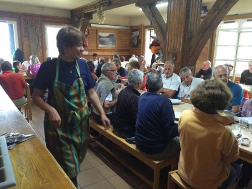 un grupo de personas sentadas en mesas en un restaurante en Refuge des étangs de Bassiès, en Auzat