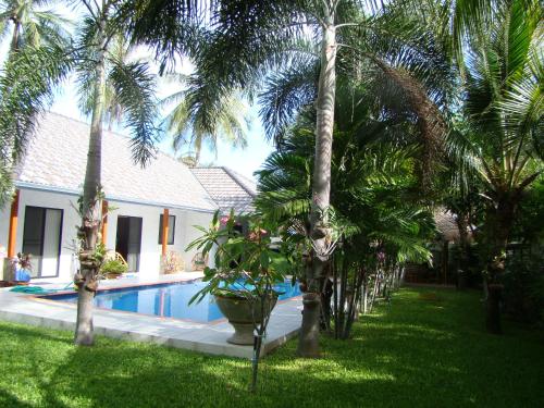 a yard with palm trees and a swimming pool at Leelawadee in Pran Buri