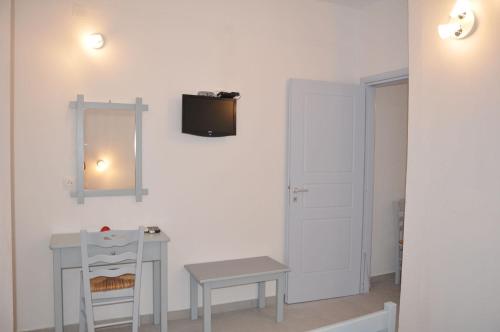 a white room with a table and a mirror at Studios Akrogiali in Aegiali