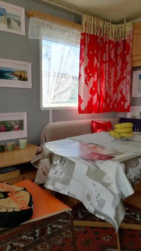 een woonkamer met een tafel en een raam bij Mobil home vacances in Plouguerneau