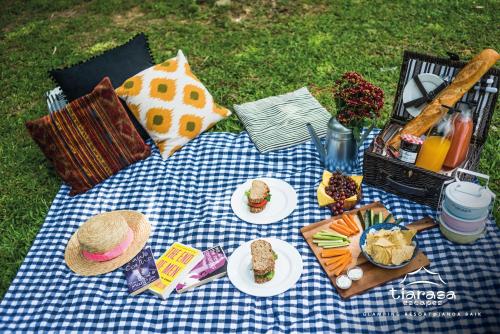 a picnic blanket with plates of food on it at Tiarasa Escapes Glamping Resort in Bukit Tinggi