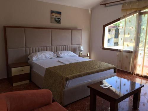 una camera da letto con un letto, una sedia e un tavolo di Hotel Pishat e Buta a Golem