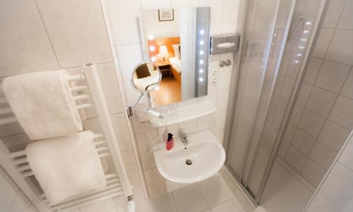 
a bathroom with a sink, toilet and shower at Hotel Carlton Mayfair in Düsseldorf
