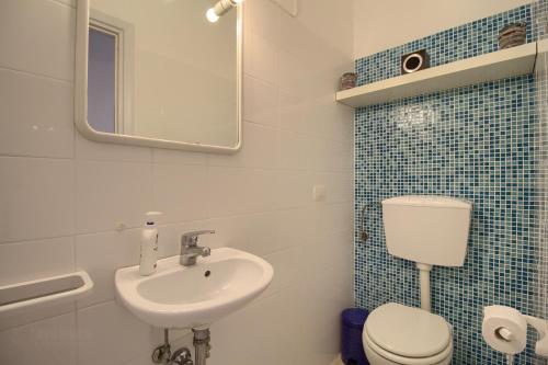 un bagno con lavandino, water e specchio di Scialandre by LoveSud a Patù