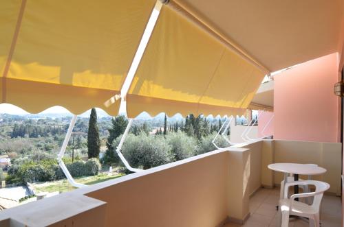 a view from the balcony of a building with a table and chairs at Penelope Apartment Hotel in Dassia