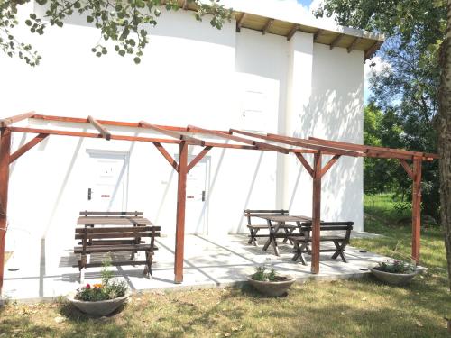a group of picnic tables and benches under a pavilion at Dve kuce pored jezera in Palić