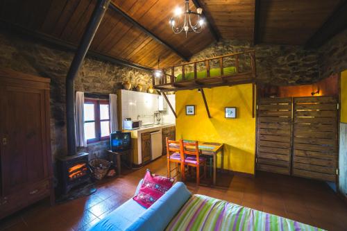 uma sala de estar com um sofá, uma mesa e uma cozinha em Caserío da Castiñeira em Sas do Monte