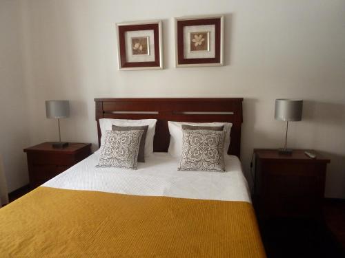 ナザレにあるCasa do Norteのベッドルーム1室(ランプ2つ、枕2つ付)