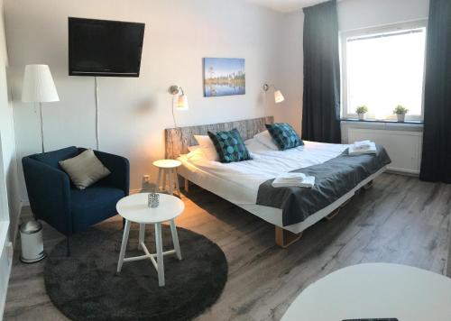 um quarto com uma cama, uma cadeira e uma mesa em Långbergets Sporthotell em Sysslebäck