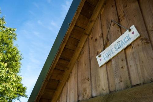a sign on the side of a wooden wall at The Love Shack nr Elie & St Andrews in Ceres