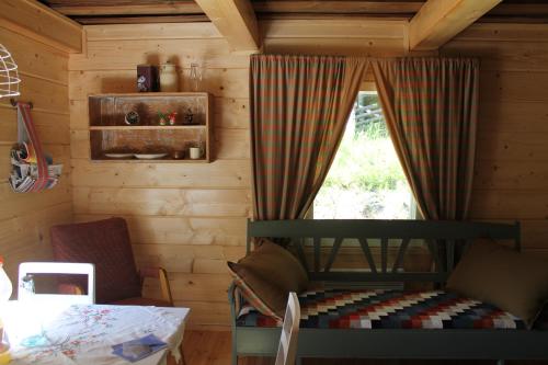 Zimmer mit einem Bett und einem Fenster in einer Hütte in der Unterkunft Metsäpirtti in Kolinkylä