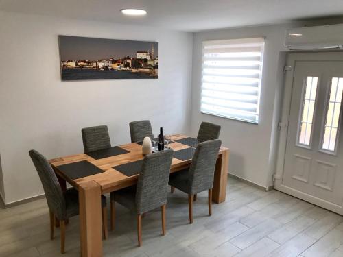 a dining room with a wooden table and chairs at Apartma Sonja in Piran