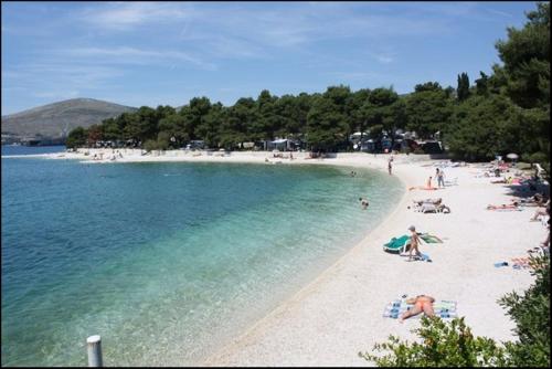 a group of people on a beach in the water at Apartments Milas in Trogir