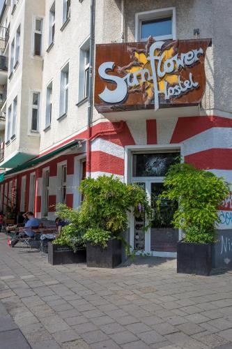 un magasin avec une enseigne sur le côté d'un bâtiment dans l'établissement Sunflower Hostel Berlin, à Berlin
