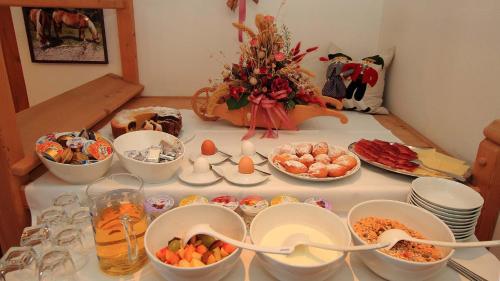 a table topped with bowls and plates of food at Bed and Breakfast Iman in Santa Cristina in Val Gardena