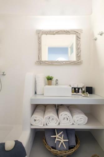 a bathroom with a sink and a mirror and towels at Panorea Complex - Mykonos in Ano Mera