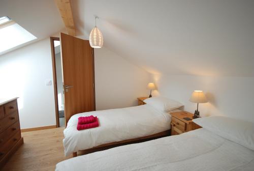 a bedroom with two beds with white sheets and red pillows at Les Sept Étoiles in Le Monêtier-les-Bains