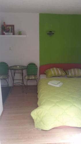 a bed in a room with a green wall at Guesthouse Panorama in Mostar