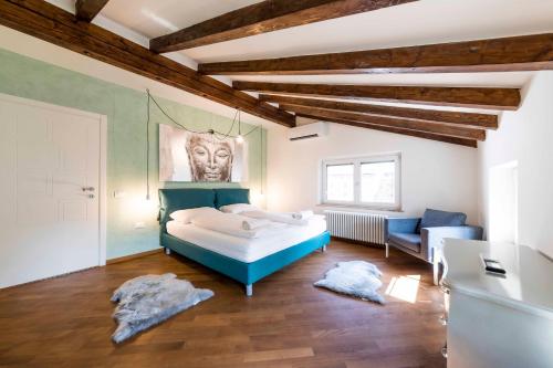 een slaapkamer met een bed, een bank en een stoel bij Stay COOPER l Goethe Suite in Bolzano