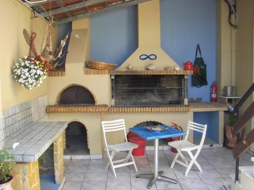 a patio with a stove and a table and chairs at Artemis GreenHill in Vravrona