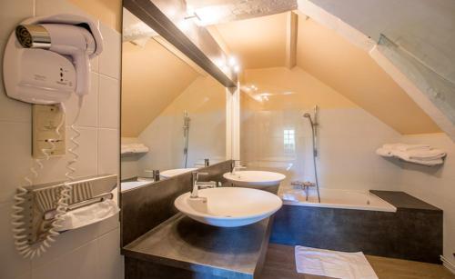La salle de bains est pourvue de 2 lavabos et d'une baignoire. dans l'établissement auberge le relais, à Reuilly-Sauvigny