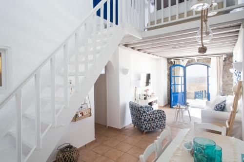 a white staircase in a living room with a table and chairs at Panorea Complex - Mykonos in Ano Mera