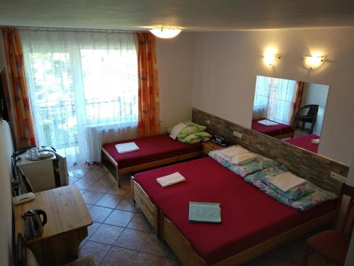 Habitación pequeña con 2 camas y espejo. en Hotelik Komandor, en Władysławowo