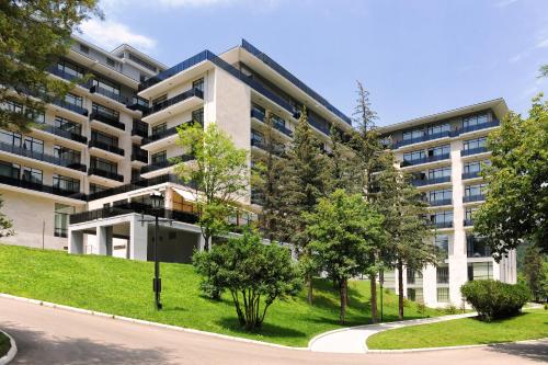 an apartment building with trees in front of it at Borjomi Likani Health & Spa Centre in Borjomi