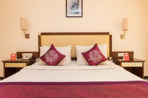 a bedroom with a large bed with two night stands at Hotel Nandi in Ujjain