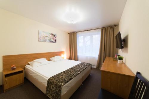 Pokój hotelowy z łóżkiem i biurkiem w obiekcie Gerda w mieście Mytiszczi