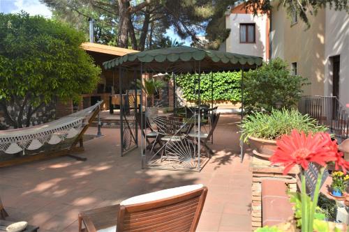 a patio with chairs and a table and an umbrella at B&B Betulla dell'Etna in Nicolosi