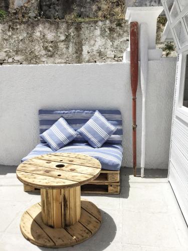 a bed with blue pillows and a wooden table at Gigi Rooms in Poros
