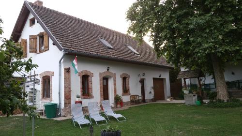 a group of chairs in front of a house at Árpád Ház in Alsónána