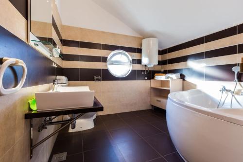 łazienka z białą wanną i umywalką w obiekcie Apartments Villa Orion w mieście Kožino