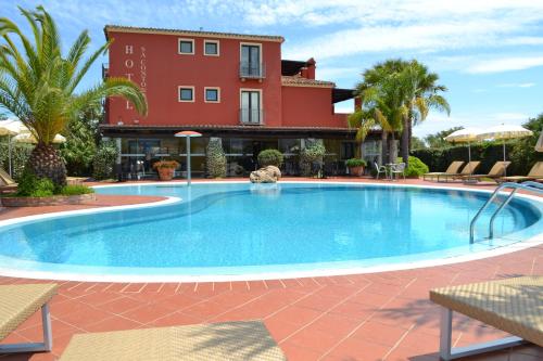 une grande piscine en face d'un bâtiment dans l'établissement Hotel Sa Contonera, à Àrbatax