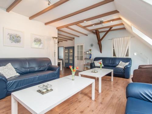una sala de estar con sofás azules y una mesa. en Child friendly and cosy farmhouse, en 't Zand