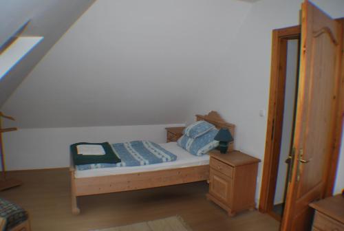 a small bedroom with a bed and a dresser at Rozália Vendégház in Sarród