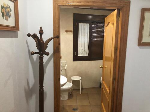 a bathroom with a toilet and a window and a door at Hotel Restaurante Calderon in Arcos de la Frontera