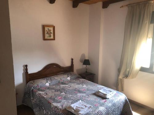 a bedroom with a bed with a comforter on it at Hotel Restaurante Calderon in Arcos de la Frontera