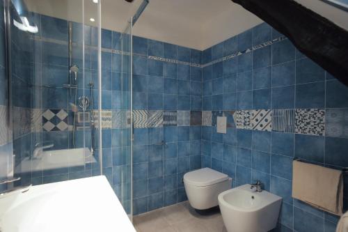 Baño de azulejos azules con aseo y lavamanos en Orto al Mare Room Rental, en Riomaggiore