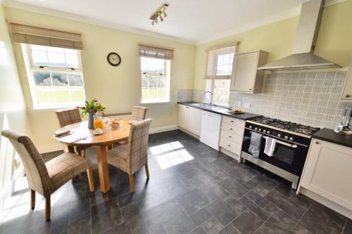a kitchen with a table and chairs and a stove at Knocklea in Alness