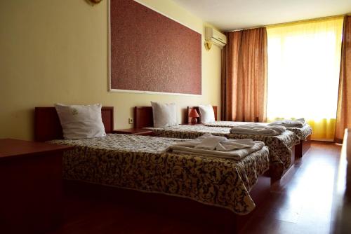 a hotel room with two beds and a window at Ryor Hotel - Restaurant & Free Parking in Sunny Beach