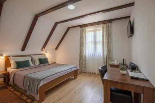 a bedroom with a bed and a desk and a window at Rooms Imperial House in Plitvička Jezera